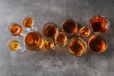 Gri masada, düz yerde, bardakta farklı leziz içkiler.