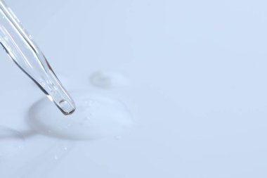 Cam boru ve şeffaf sıvı beyaz arka planda, yakın plan. Metin için boşluk