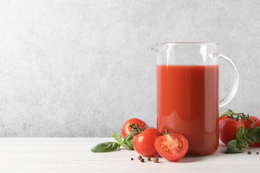 Lezzetli domates suyu, fesleğen, karabiber ve sebzeler beyaz ahşap masa içinde. Metin için boşluk