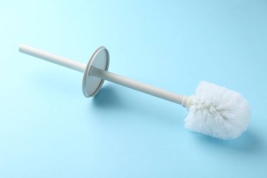 Açık mavi arkaplanda beyaz tuvalet fırçası