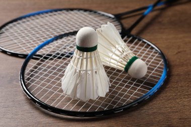 Tüylü badminton mekikleri ve raketleri ahşap masada yakın plan