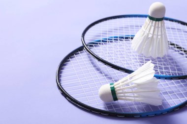 Menekşe arka planda badminton mekikleri ve raketleri yakın plan. Metin için boşluk