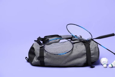 Tüy badminton mekik horozları, raketler ve çanta menekşe arka planda