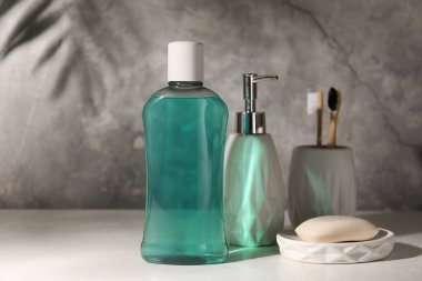 Bir şişe gargara, diş fırçası ve banyo masasının üzerindeki sabun.