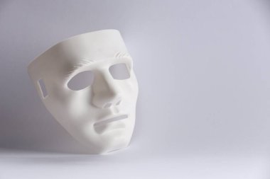 Beyaz arka planda plastik yüz maskesi, metin için boşluk. Tiyatro performansı