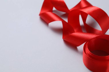 Beyaz arka planda güzel bir kırmızı kurdele, yakın plan. Metin için boşluk