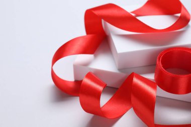 Beyaz arkaplanda güzel kırmızı kurdele ve podyumlar, yakın plan