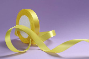 Menekşe arkaplanda güzel sarı kurdele makarası, yakın plan.