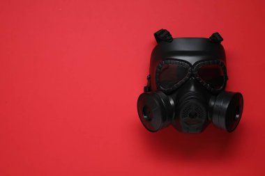 Kırmızı arka planda bir gaz maskesi, üst manzara. Metin için boşluk