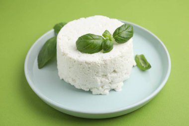 Taze ricotta (krem peynir) ve fesleğen yeşil masada, yakın plan.