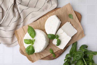 Taze ricotta (krem peynir) ve fesleğen beyaz fayanslı masa, üst görünüm