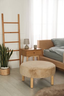 Çift kişilik yatağı ve güzel yeşil çiçekleri olan şık bir yatak odası. Modern iç mimari