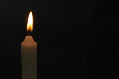 Siyah arkaplanda yanan bir kilise mumu, metin için boşluk