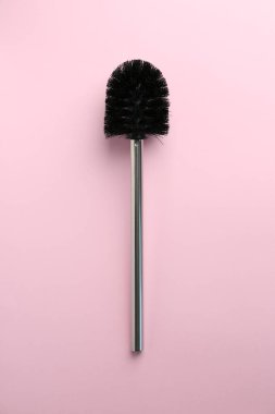 Pembe arka planda bir tuvalet fırçası, üst manzara.