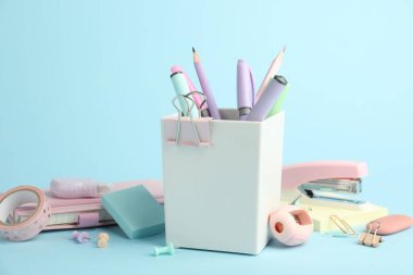 Açık mavi arkaplanda zımba ve diğer kırtasiye malzemeleri, yakın plan