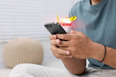 İçerde akıllı telefon kullanan bir adam, yakın plan. Yukarıdaki aygıtın üzerindeki Çöp Posta iletisi bildirimi, resimleme