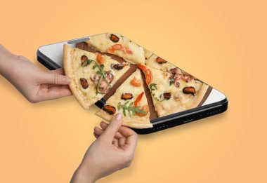 Çevrimiçi yemek siparişi. Akıllı telefondan pizza dilimleri alan arkadaşlar turuncu arka planda, yakın plan