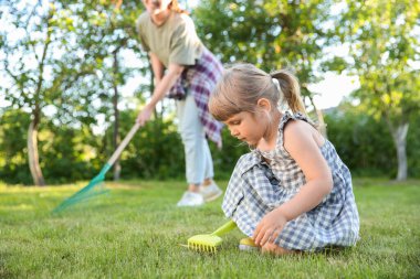 Mother and her daughter working together in garden