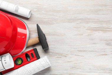 Bina seviyesi ve diğer inşaat araçları beyaz ahşap masa üzerinde düz bileşim, metin için boşluk