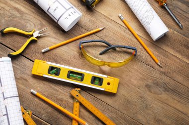 Ahşap masa üzerinde bina seviyesi ve diğer inşaat araçları ile düz bileşim yatıyordu