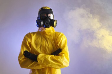 Mor arka planda duman içinde gaz maskesi takan işçiler, düşük açılı görüntüler. Metin için boşluk