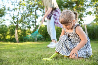 Mother and her daughter working together in garden