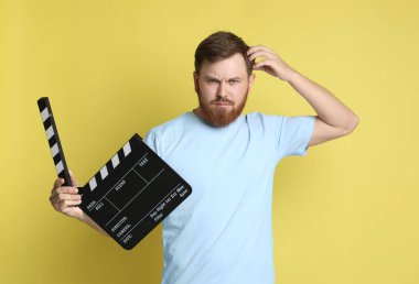 Film çekiyoruz. Sarı arka planı olan düşünceli bir adam.