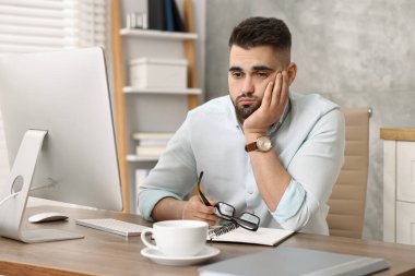 Ofiste oturan şaşkına dönmüş adam.