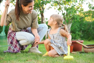 Mother and her daughter working together in garden