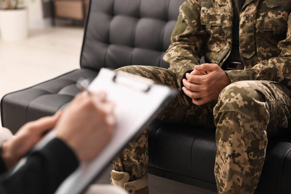 Professional psychotherapist working with military man in office, closeup
