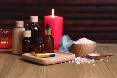 Farklı aromaterapi ürünleri, yanan mumlar ve okaliptüs yaprakları.