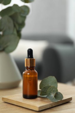 Aromaterapi. Kaliteli yağ ve okaliptüs yaprakları ahşap masada.