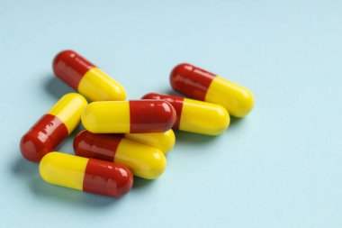 Açık mavi arka planda birçok antibiyotik hapı, yakın plan.