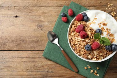 Tahta masada servis edilen böğürtlenli ve yoğurtlu lezzetli granola. Metin için boşluk