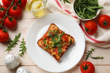 Lezzetli pizza tostları ve malzemeler açık ahşap masada, düz yatıyordu.