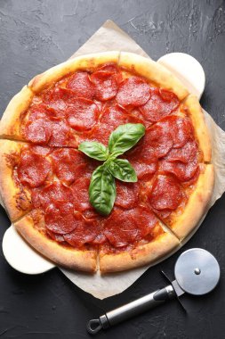 Lezzetli pepperonili pizza ve siyah desenli masa, düz uzanma