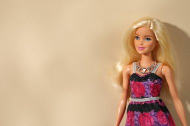 Mykolaiv, Ukrayna - 4 Eylül 2023: Bej arka planda kolye takan güzel Barbie bebek, metin için yer