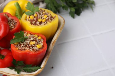 Quinoa dolma dolma dolma biber ve maydanozu beyaz fayanslı masada, yakın plan. Metin için boşluk