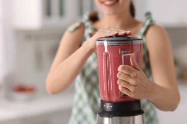 Mutfakta blender ile nefis smoothie yapan kadın, yakın plan.