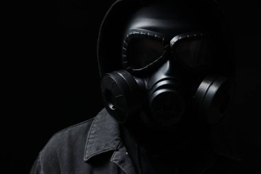 Siyah arka planda gaz maskeli adam, yakın plan.
