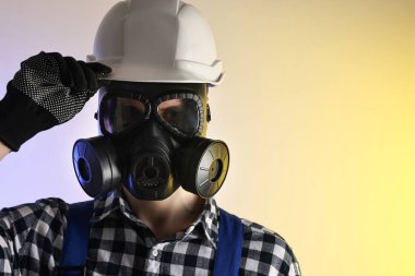 Gaz maskeli ve kask takan bir işçi. Metin için boşluk