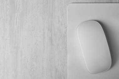 Gri ahşap masadaki fareli bir kablosuz fare, üst manzara. Metin için boşluk