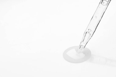 Cam boru ve şeffaf sıvı beyaz arka planda, yakın plan. Metin için boşluk