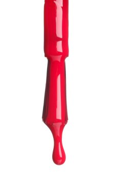 Fırçadan damlayan kırmızı oje beyaza izole edilmiş.