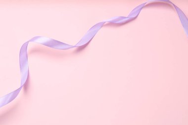 Pembe arka planda güzel bir menekşe kurdelesi, üst manzara. Metin için boşluk