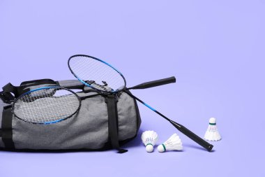Tüy badminton mekik horozları, raketler ve çanta menekşe arka planda