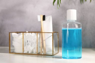 Banyodaki beyaz masada bir şişe gargara.