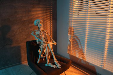 Bekleme konsepti Kapalı bir koltukta oturan insan iskeleti, metin için boşluk