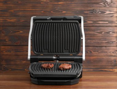 Tahta masada lezzetli biftekli elektrikli ızgara.