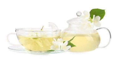 Cam bardakta Aromatik bitki çayı, çaydanlık ve beyaz üzerine izole edilmiş çiçekler.